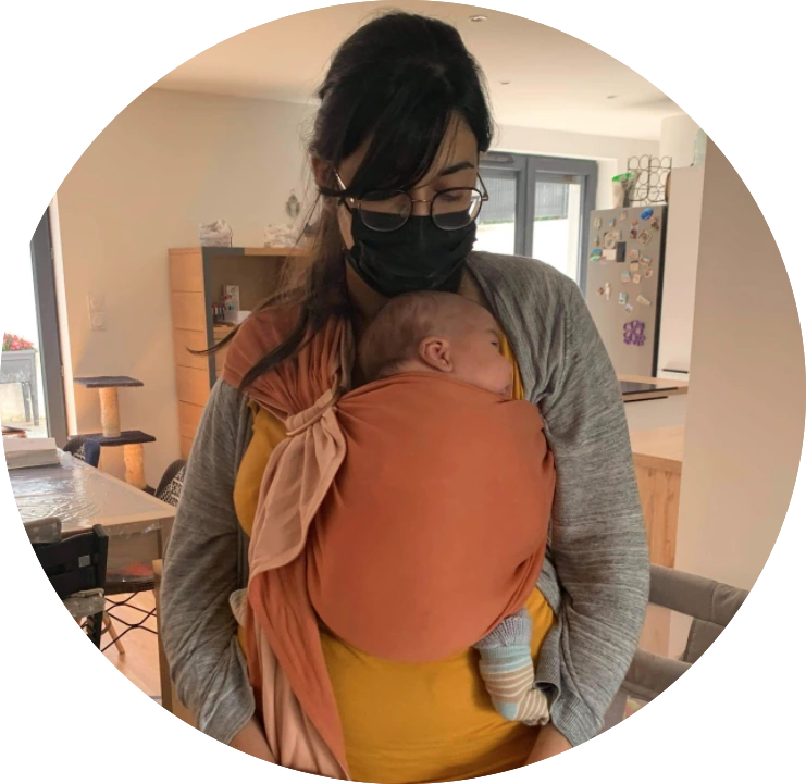 Maman portant son bébé en écharpe orange après un atelier portage à Voiron